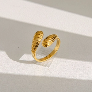 Détail d'une bague fleur dorée ouverte avec textures segmentées et finition brillante