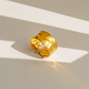 Détail de la bague large dorée à motif martelé avec anneau ouvert ajustable