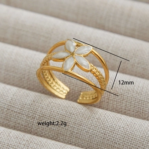 Golden double-layered open ring featuring a white floral charm and woven band texture