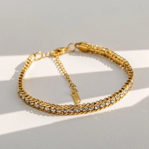 Détail d'un bracelet doré en acier inoxydable avec zircons et fermoir mousqueton robuste