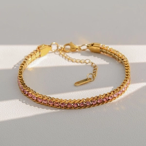 Détail d'un bracelet gourmette doré en acier inoxydable avec pierre de zircon rose