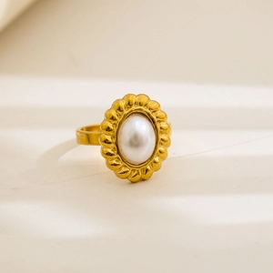 Detailed close-up of a vintage gold-plated ring with an oval pearl and wave engraving