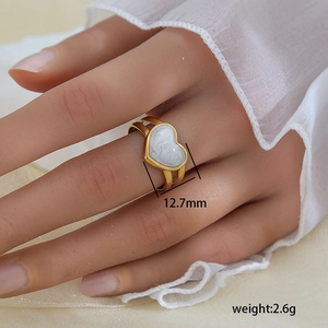 Detalle de anillo de corazón en acero dorado 18K con incrustación de mármol y ancho 12,7 mm
