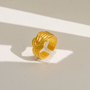 Gros plan détaillé d'une bague nœud torsadé dorée sur une surface en cuir texturé
