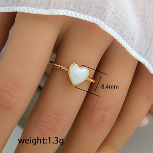 Gedrehter Goldring mit weißem Emaille-Herz und eleganter Seilstruktur am Band