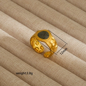 Detail of 18K gold-plated irregular ring with hammered texture and green stone inlay