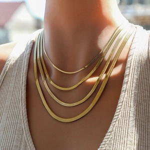 Vierlagige goldene Schlangenkette in verschiedenen Breiten am Hals eines Models