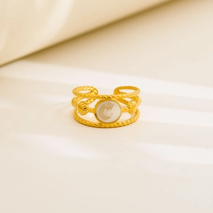 Macro shot of gold vintage ring with twisted bands, white inlay and shell details