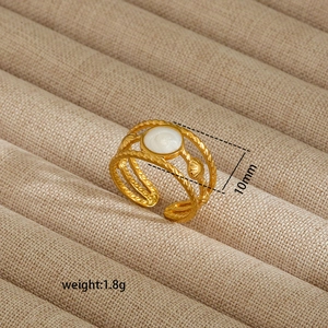 Detailed macro of a 10mm golden irregular ring with white shell inlay and shell charms
