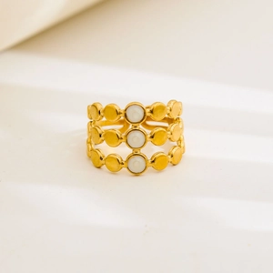 Macro detail of gold-plated stainless steel open ring with white enamel dots