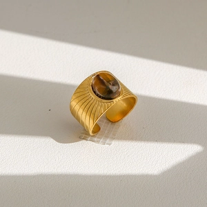 Détail macro de la bague vintage dorée avec œil de tigre et gravure radiale