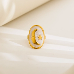 Detail of vintage gold ring with white enamel oval face and celestial star moon patterns