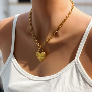 Gold OT toggle necklace with chunky heart pendant and radiant texture on model