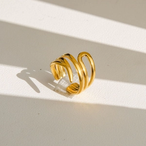 Gros plan de la bague dorée ondulée multicouche montrant un lustre métallique poli