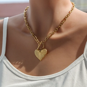 Fashionable gold heart pendant necklace with textured finish and OT clasp on model