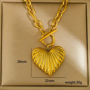 Exaggerated golden heart pendant necklace with shell texture and toggle clasp design