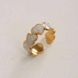Bague ajustable en acier doré ornée de breloques en nacre blanche en forme de cœur