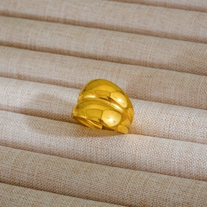 Dettaglio di un anello d'oro a doppio strato con finitura lucida su vassoio di lino