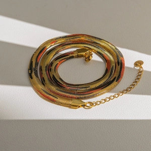Detalle de cadena de serpiente dorada con textura de tigre naranja y negra y cierre de mosquetón