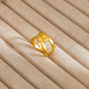 Detail shot of vintage style gold layered interlaced ring on beige fabric display