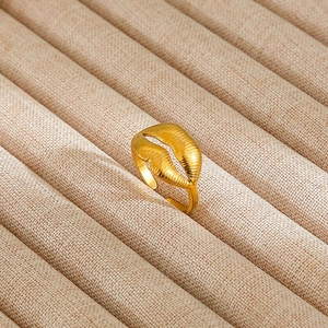 Macro detail of adjustable gold lips ring with radial texture on a burlap jewelry stand
