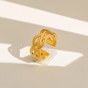 Vue macro de la texture tressée dorée et du design ouvert sur cette bague chic