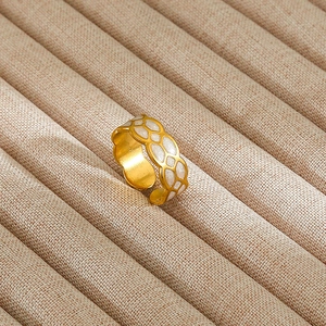 Detail of gold-plated open ring featuring a white honeycomb geometric texture design