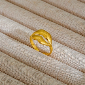 Macro di un anello dorato a forma di labbra con texture fini su un vassoio per gioielli
