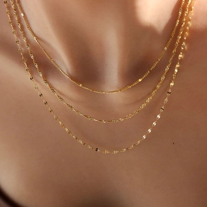 Ensemble de colliers superposés en acier inoxydable plaqué or 18 carats sur modèle