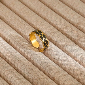 Detailed macro view of black enamel giraffe pattern on an adjustable gold stainless steel ring
