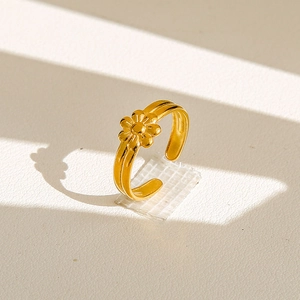 Vue détaillée d'une bague fleur dorée avec anneau ajustable sur une surface texturée