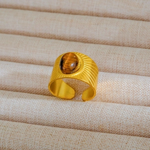 Dettaglio anello vintage dorato con pietra occhio di tigre e incisioni a raggiera