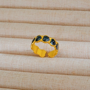 Dettaglio macro dell'anello regolabile dorato con intarsio in smalto blu a cuore