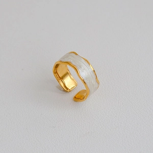 Dettaglio anello largo vintage placcato oro con intarsio in smalto a onde bianche