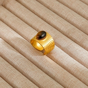 Macro detail of gold-plated sunburst ring with oval tiger eye stone and open adjustable band