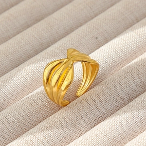 Dettaglio dell'anello a nodo in acciaio inossidabile placcato oro 18k su vassoio beige