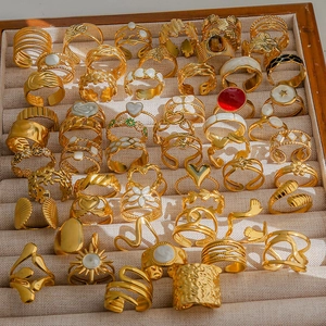 Ensemble de bagues dorées bohèmes avec perles et fleurs sur plateau velours