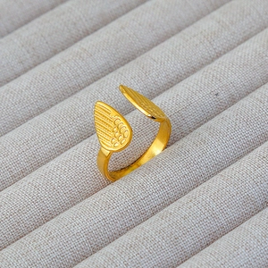 Dettaglio dell'anello in acciaio inossidabile placcato oro 18k con design ali d'angelo