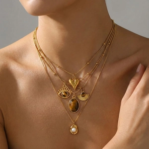 Collana a strati in acciaio inox oro 18K con ciondoli a cuore, occhio e perla su modella