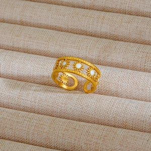 Dettaglio anello a margherita dorato con smalto bianco su espositore per gioielli beige