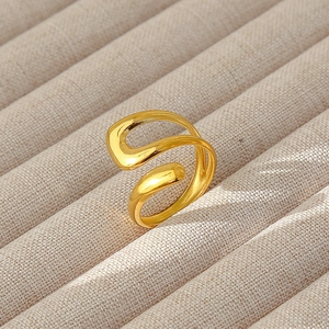 Dettaglio dell'anello a onda minimalista placcato oro 18k su espositore per gioielli beige