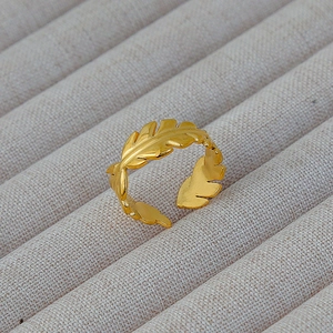 Dettaglio dell'anello aperto a foglia dorata con texture metallica opaca fine