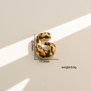 Detalle del colgante en forma de G con estampado de leopardo y altura de 23,9 mm