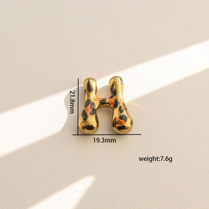 Detalle del colgante letra H dorada con acabado de leopardo y altura de 21,8 mm