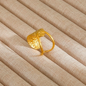 Detail of vintage gold shield ring with hammer-textured finish on a fabric tray