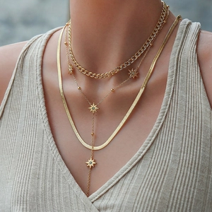 Gold layered necklace set with chunky Cuban chain star charms and sleek snake chain