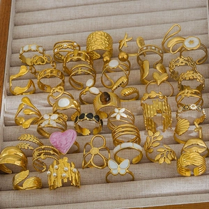 Assortimento di anelli dorati con perle e smalto in un portagioie di velluto