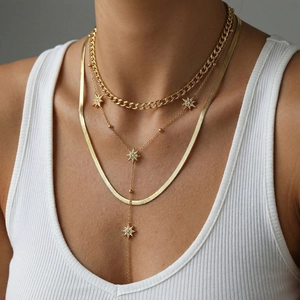 Three-layer gold layered necklace set with flat snake chain and star pendant on a model