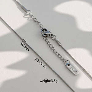 Détail d'une chaîne serpent en acier de 0.9mm avec fermoir mousqueton et gravure S.STEEL