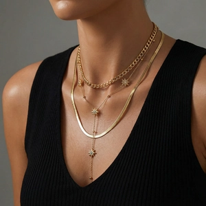 Layered gold necklace set featuring curb chain, star pendant and herringbone chain